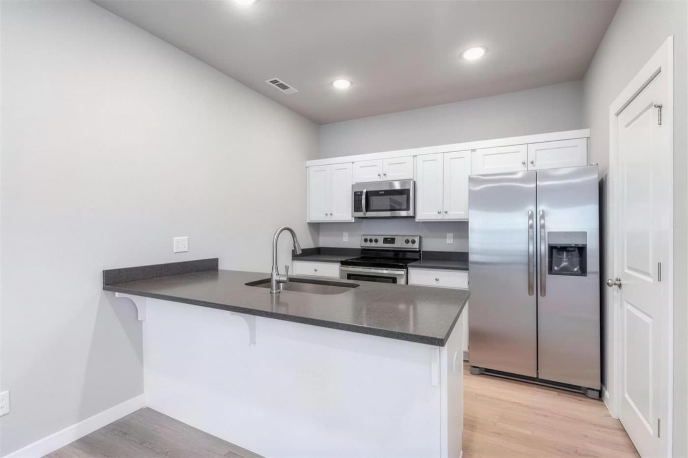 A kitchen with an island and stainless appliances